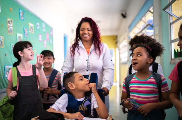 Crianças e professores exercendo uma educação Inclusiva na escola.